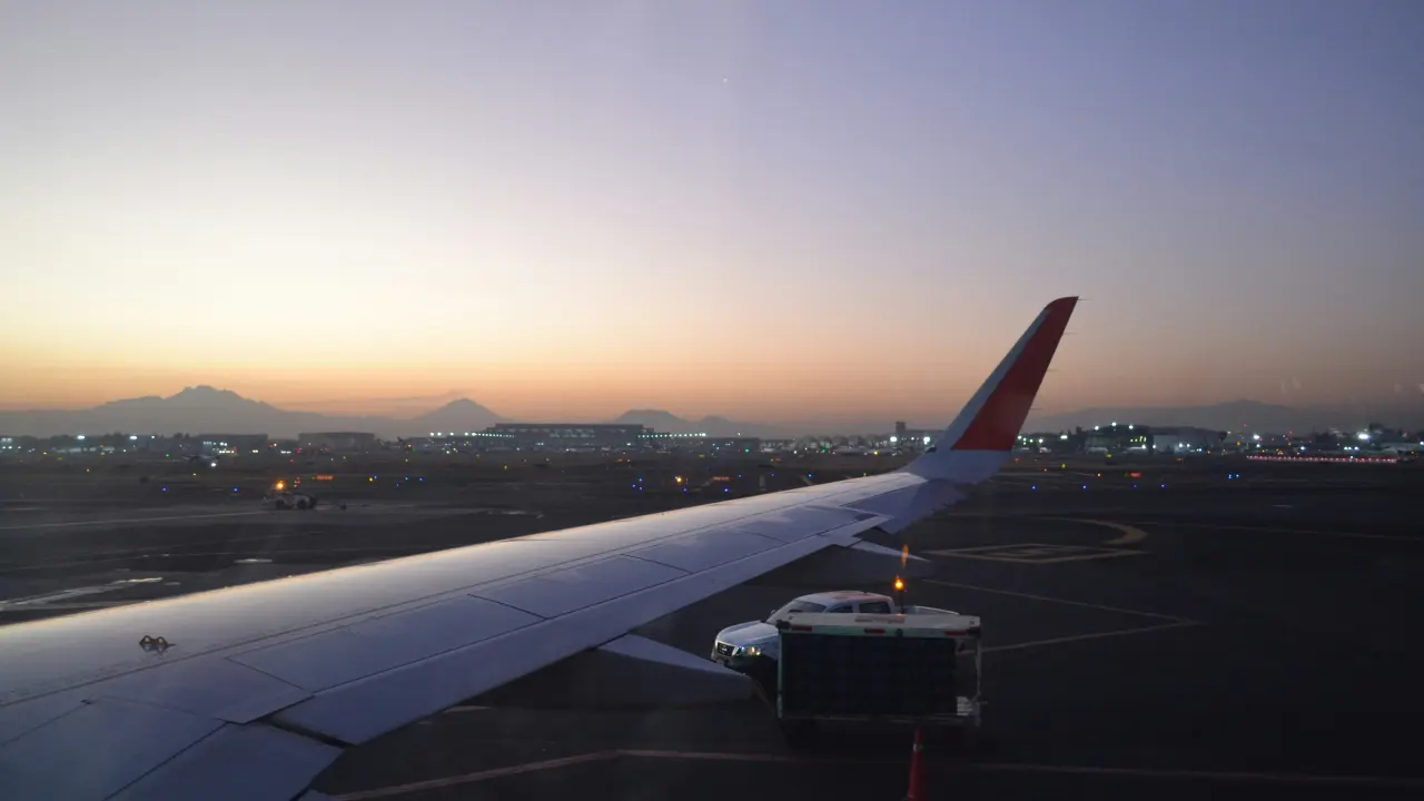 Passenger aircraft wing at sunset, seen from the window seat