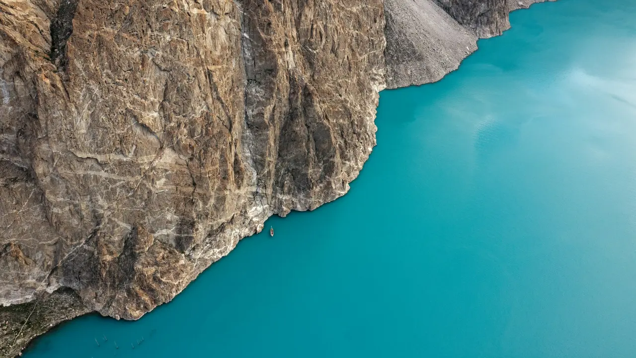Aerial view of the turquoise water of Attabad Lake below rocky mountains in Hunza